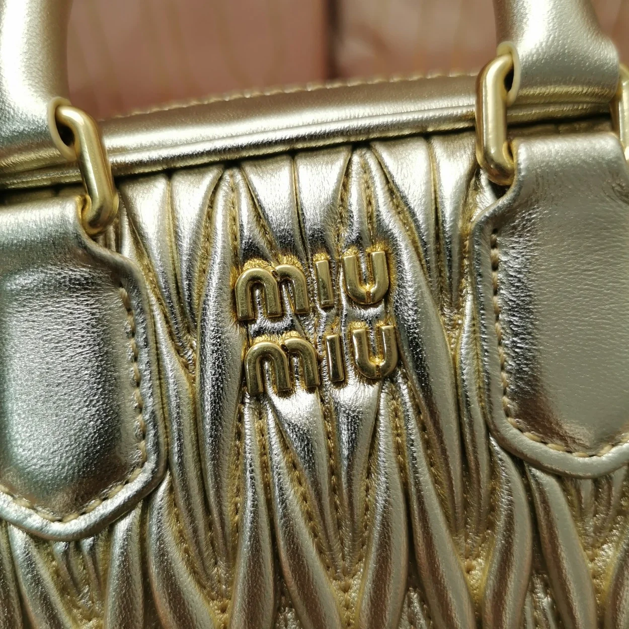 미우미우 마테라쎄 나파 가죽 탑 핸들 미니백 골드